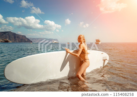 Woman sup sea travel in black bikini. Portrait of a happy girl on the background of a surfboard in the sea on a sunny summer day 115408258