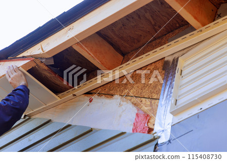 Soffit board in white vinyl uPVC installed along roofline of house below fascia roof. Soffit board in white vinyl uPVC installed along roofline of house below fascia roof. 115408730