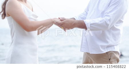 Happy young, Portrait of a young couple holding hands, the groom holds the bride's hand on the background of a natural country, the bride and groom Happy young, Portrait of a young couple holding hands, the groom holds the bride's hand on the background of a natural country, the bride and groom 115408822