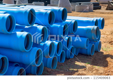 On construction site, there are blue PVC pipes for laying pipe water system to new house 115409063