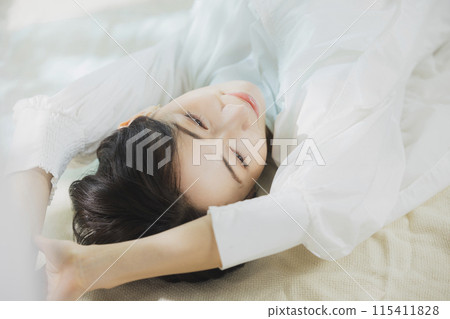 Woman lying on bed Woman lying on bed 115411828