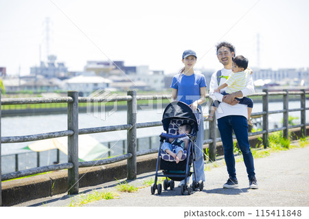 家長和孩子推著嬰兒車沿著河岸行走 家長和孩子推著嬰兒車沿著河岸行走 115411848