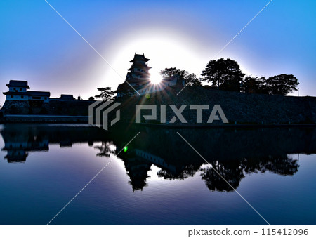 Early May morning: The silhouette of Imabari Castle shining against the sunlight. Its silhouette is also reflected in the moat. Early May morning: The silhouette of Imabari Castle shining against the sunlight. Its silhouette is also reflected in the moat. 115412096