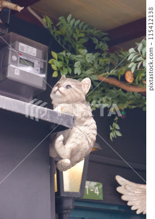 A cat sculpture on the eaves of a house 115412138