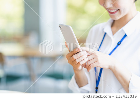 A female employee operating a smartphone. (Parts) 115413039