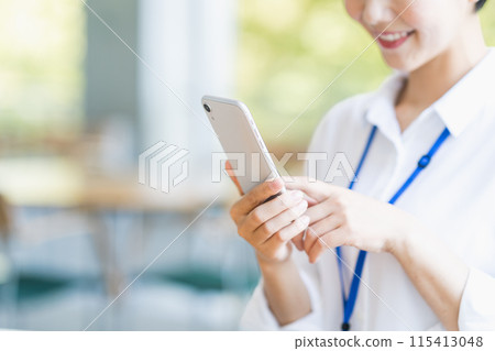 A female employee operating a smartphone. (Parts) 115413048