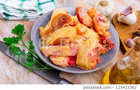 Uncooked chicken and condiments on kitchen table 115413362
