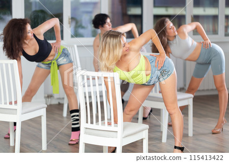 Putting foot hand on seat of chair, girl improvises, perform lap dance during group master class 115413422