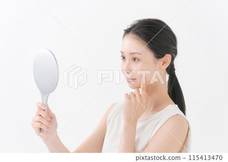Pretty woman looking in the mirror 115413470