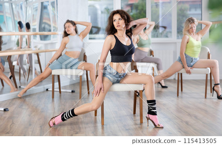 Sitting on chair, girl with long hair train to perform lap dance, interacting with imaginary partner Sitting on chair, girl with long hair train to perform lap dance, interacting with imaginary partner 115413505