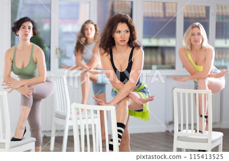 Putting foot hand on seat of chair, girl improvises, perform lap dance during group master class Putting foot hand on seat of chair, girl improvises, perform lap dance during group master class 115413525