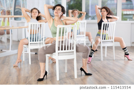 Sitting on chair, woman with haircut train to perform lap dance, interacting with imaginary partner 115413554