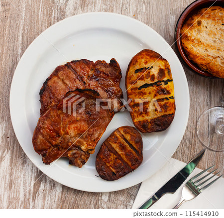 Delicious pork chop with potatoes and parsley 115414910