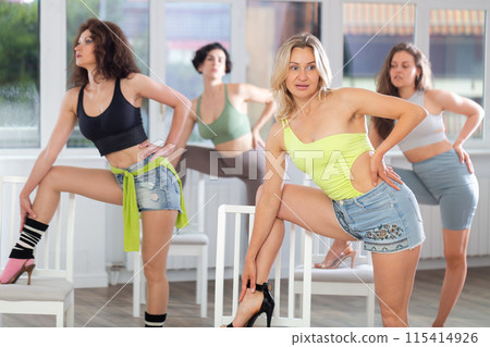 Expressive blonde in heels performing burlesque choreography with chair Expressive blonde in heels performing burlesque choreography with chair 115414926