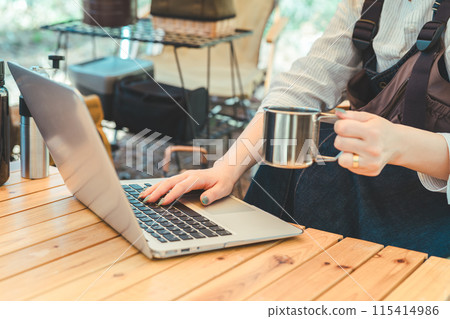 The hands of a female camper working remotely at a campsite The hands of a female camper working remotely at a campsite 115414986