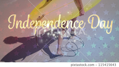 Person carries a yellow surfboard under the Independence Day text 115415643
