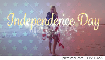 Young Caucasian woman wrapped in an American flag on a beach Young Caucasian woman wrapped in an American flag on a beach 115415658