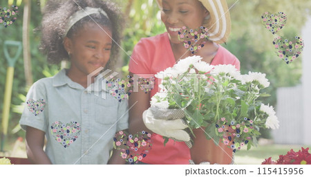 Image of hearts over smiling african american mother and daughter gardening plants 115415956