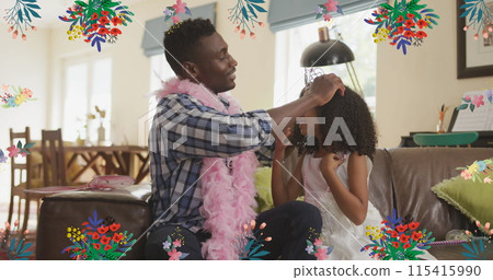 Image of flowers over happy african american father putting crown to daughter at home 115415990