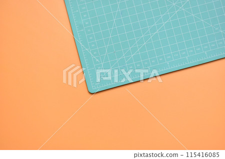 green cutting mat on orange background, object tool for design 115416085