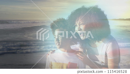 Image of happy african american mother and son at beach on sunny day smiling over sea 115416528