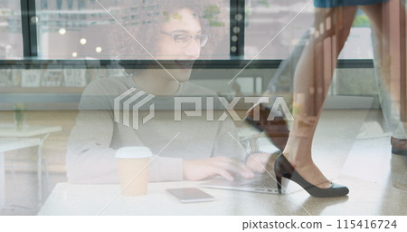 Image of smiling woman using laptop at cafe over colleagues walking in modern building 115416724