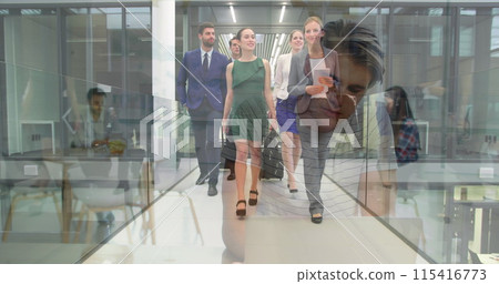 Image of smiling man using laptop over happy colleagues with luggage walking in corridor 115416773