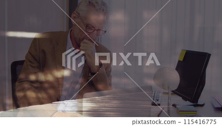 Image of businessman using laptop, over sped up commuters walking 115416775