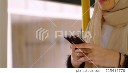Image of asian woman in hijab using smartphone over cityscape 115416778