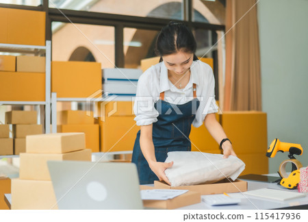 Online small business owners are packing their ordered products that customers order online into a box .concept of online shopping Online small business owners are packing their ordered products that customers order online into a box .concept of online shopping 115417936