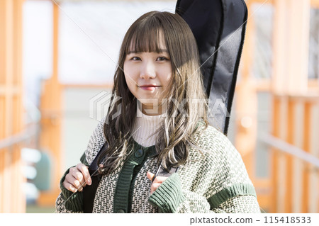 戶外攜帶吉他盒的年輕女子 戶外攜帶吉他盒的年輕女子 115418533