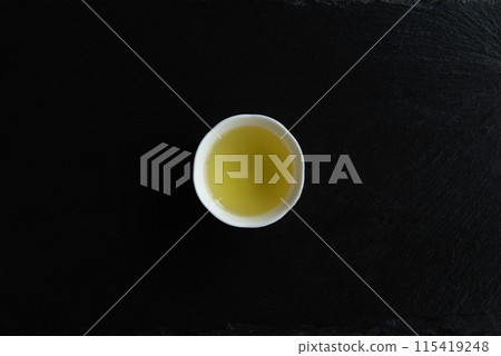 Cup of a Green tea on a black background. Minimalistic Beauty. 115419248
