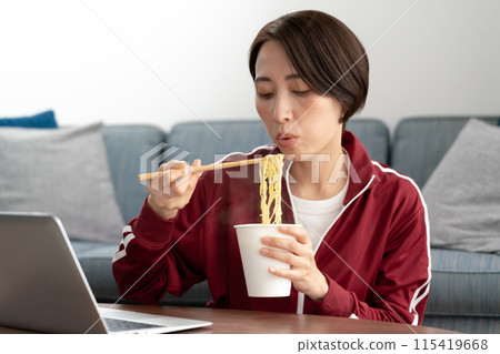 A woman eating cup ramen 115419668