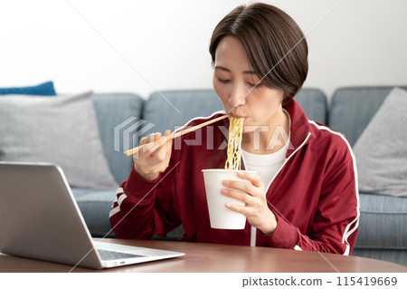 A woman eating cup ramen A woman eating cup ramen 115419669