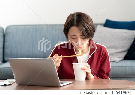 A woman eating cup ramen A woman eating cup ramen 115419675