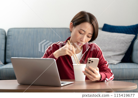 A woman eating cup ramen A woman eating cup ramen 115419677