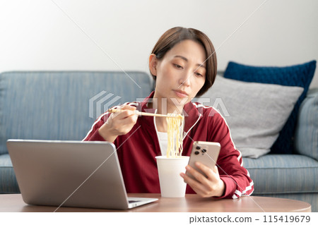 A woman eating cup ramen 115419679