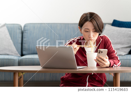 A woman eating cup ramen A woman eating cup ramen 115419683