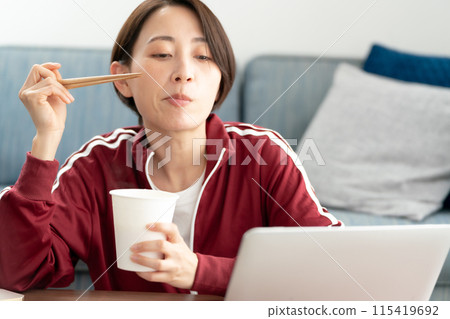 A woman eating cup ramen A woman eating cup ramen 115419692