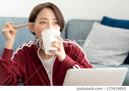 A woman eating cup ramen A woman eating cup ramen 115419693