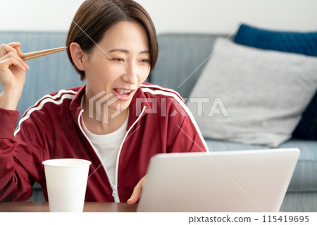 A woman eating cup ramen A woman eating cup ramen 115419695