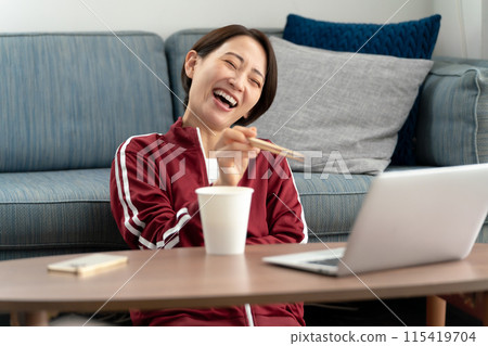 A woman eating cup ramen 115419704