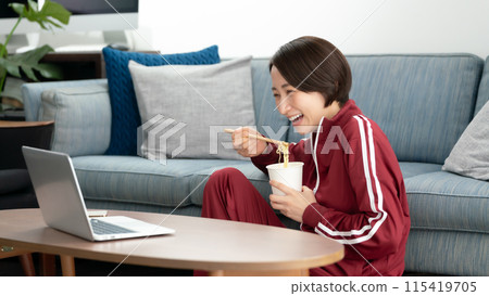A woman eating cup ramen 115419705