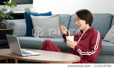 A woman eating cup ramen 115419706