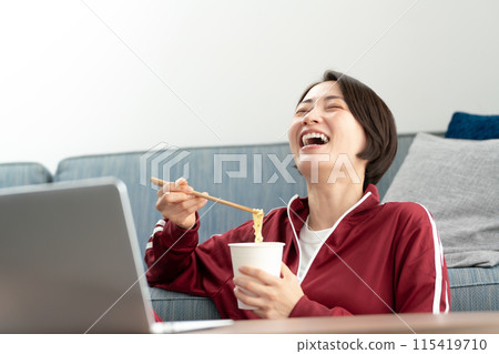 A woman eating cup ramen 115419710