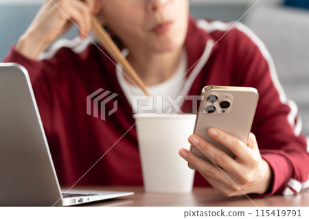 手邊吃杯拉麵的女人 115419791