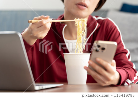 Woman eating cup ramen 115419793