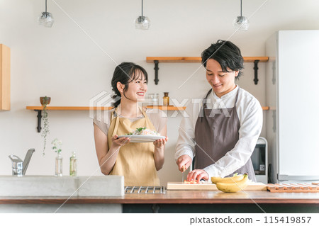 一對夫婦在廚房做飯/一個男人用刀切菜 115419857