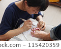 A woman having a nail treatment 115420359