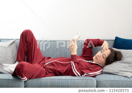 Woman looking at smartphone on sofa, stressed Woman looking at smartphone on sofa, stressed 115420573